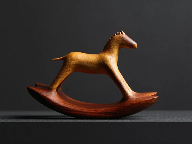 Cheval à bascule en bois artisanal sur un piédestal sombre, éclairage latéral dramatique